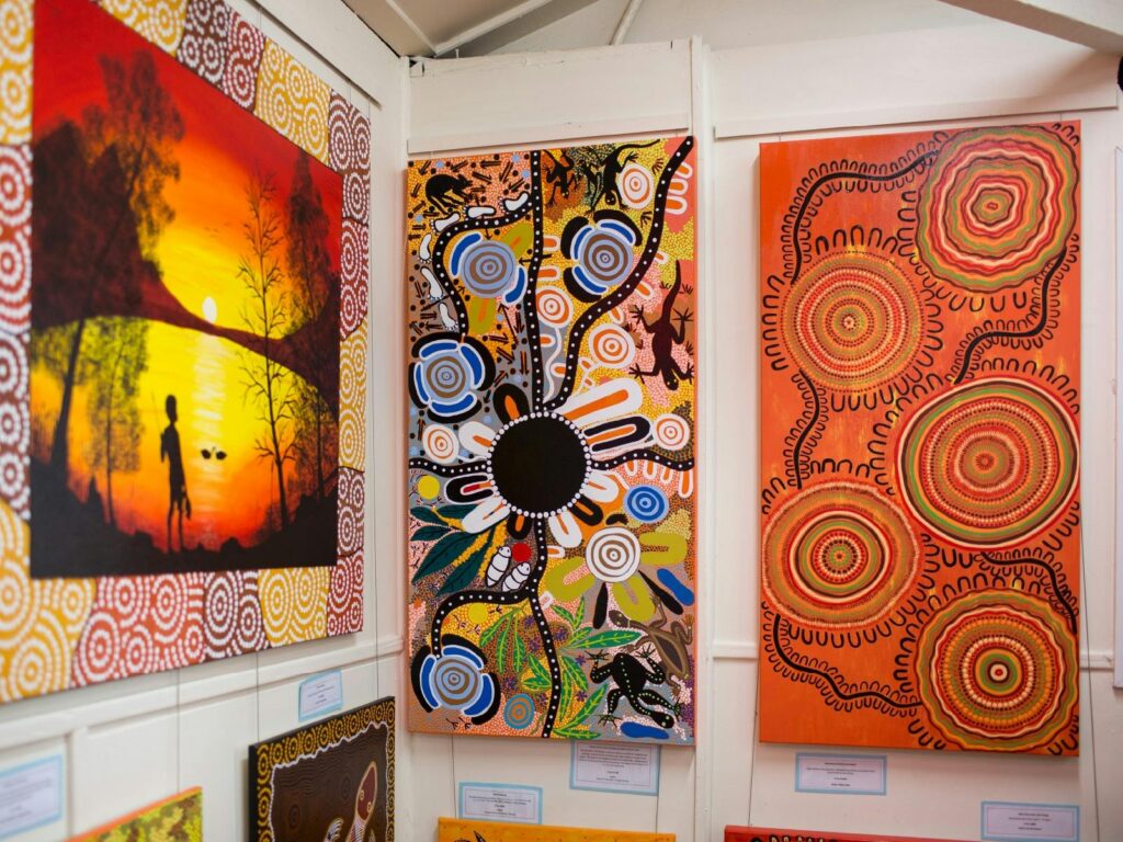 Colourful Aboriginal artworks hanging on a wall